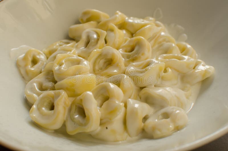 Το proscitto ` - tortellini panna ε tortellini πιάτων ` με την άσπρη σάλτσα - χαρακτηριστικά ιταλικά τρόφιμα στοκ εικόνες