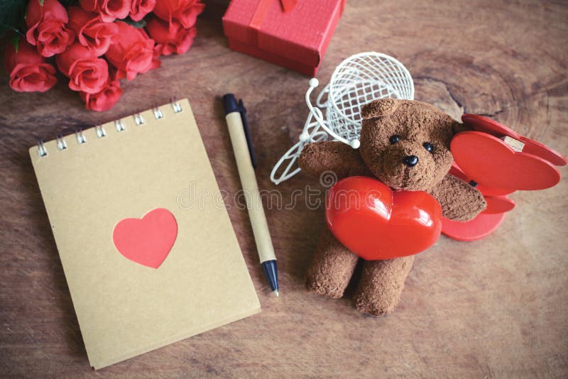 Το Teddy αφορά με την κόκκινη μορφή και το σημειωματάριο καρδιών το παλαιό ξύλινο backg στοκ φωτογραφία Το Teddy αφορά με την κόκκινη μορφή και το σημειωματάριο καρδιών το παλαιό ξύλινο backg στοκ φωτογραφία