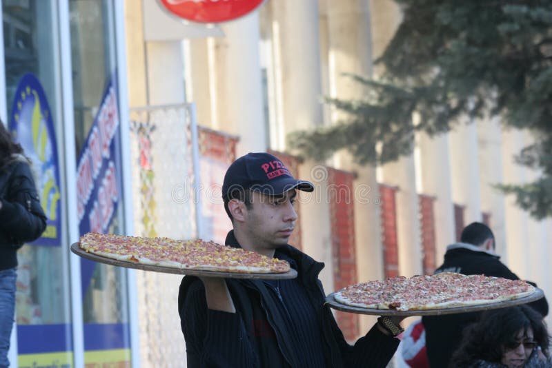 Το άτομο παράδοσης πιτσών φέρνει τις πίτσες παραδίδει επάνω την οδό Pernik, Βουλγαρία †«στις 26 Ιανουαρίου 2008 στοκ εικόνες με δικαίωμα ελεύθερης χρήσης Το άτομο παράδοσης πιτσών φέρνει τις πίτσες παραδίδει επάνω την οδό Pernik, Βουλγαρία †«στις 26 Ιανουαρίου 2008 στοκ εικόνες με δικαίωμα ελεύθερης χρήσης