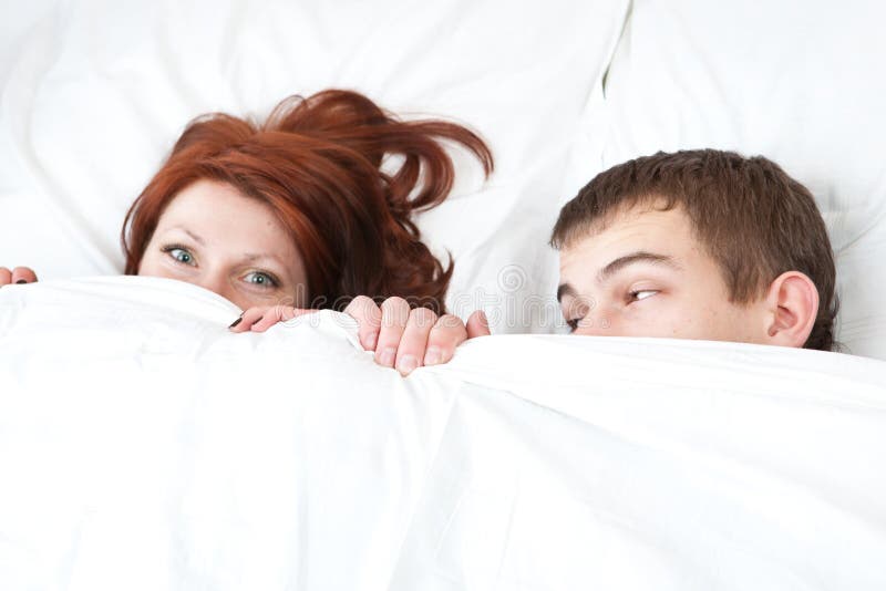 Boy and girl are hiding under the blanket. Boy and girl are hiding under the blanket