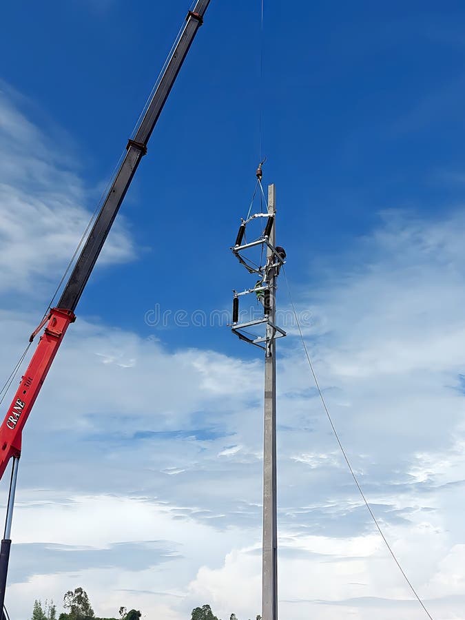το γερανό σηκώνει διακόπτη αποσύνδεσης 115 kv στο σημείο εγκατάστασης, ενώ ο εργαζόμενος περιμένει στοκ εικόνες