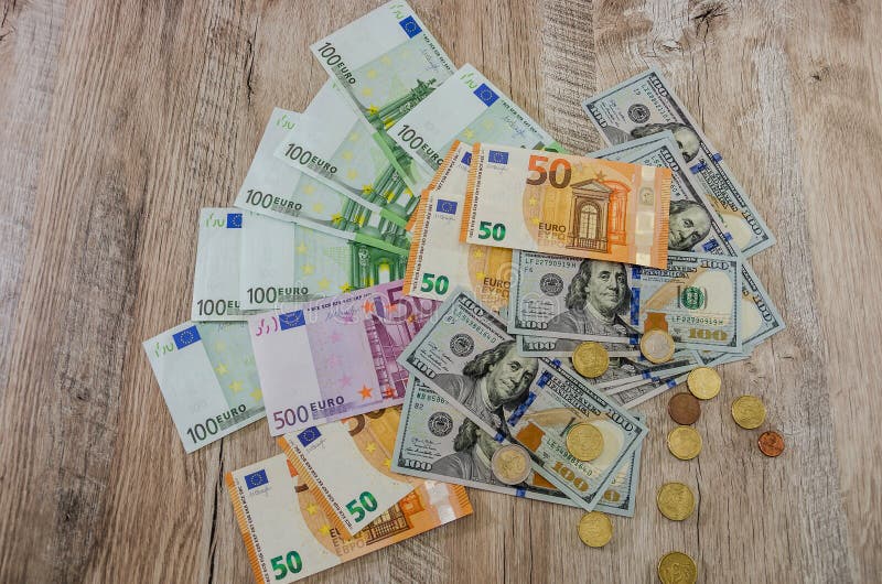 Το ευρώ, δολάρια, σεντ διαδίδει έξω σε ένα ξύλινο υπόβαθρο στοκ φωτογραφία με δικαίωμα ελεύθερης χρήσης Το ευρώ, δολάρια, σεντ διαδίδει έξω σε ένα ξύλινο υπόβαθρο στοκ φωτογραφία με δικαίωμα ελεύθερης χρήσης