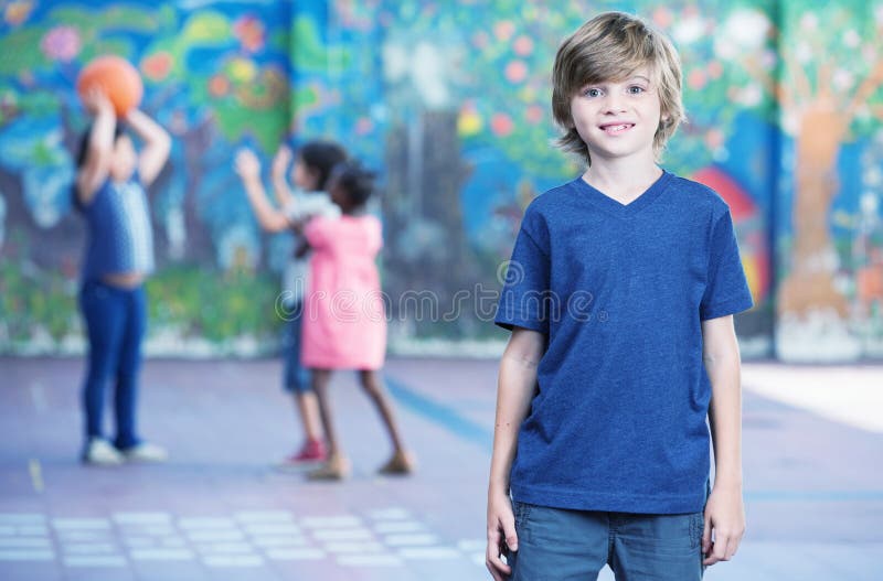 Το ευτυχές παιδί που χαμογελά schoolyard με άλλο να παίξει επάνω
