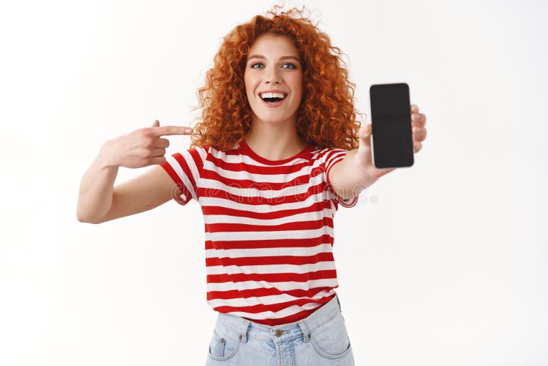Το ζωηρό χαρισματικό εύθυμο redhead θηλυκό προωθεί τρομερό app επεκτείνει τη κάμερα βραχιόνων παρουσιάζει οθόνη smartphone δείχνο στοκ φωτογραφία Το ζωηρό χαρισματικό εύθυμο redhead θηλυκό προωθεί τρομερό app επεκτείνει τη κάμερα βραχιόνων παρουσιάζει οθόνη smartphone δείχνο στοκ φωτογραφία