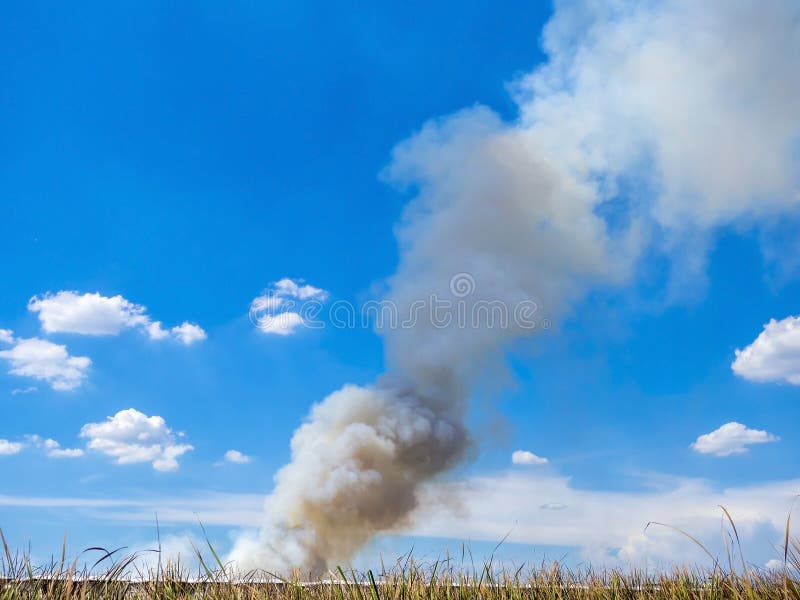 Burning house causes a big pile of smoke, black smoke rising up to blue sky background. Burning house causes a big pile of smoke, black smoke rising up to blue sky background.