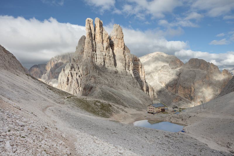 Το καταφύγιο Montain απεικονίζει πέρα από μια μικρή λίμνη δίπλα στους πύργους Vajolet στοκ εικόνα με δικαίωμα ελεύθερης χρήσης