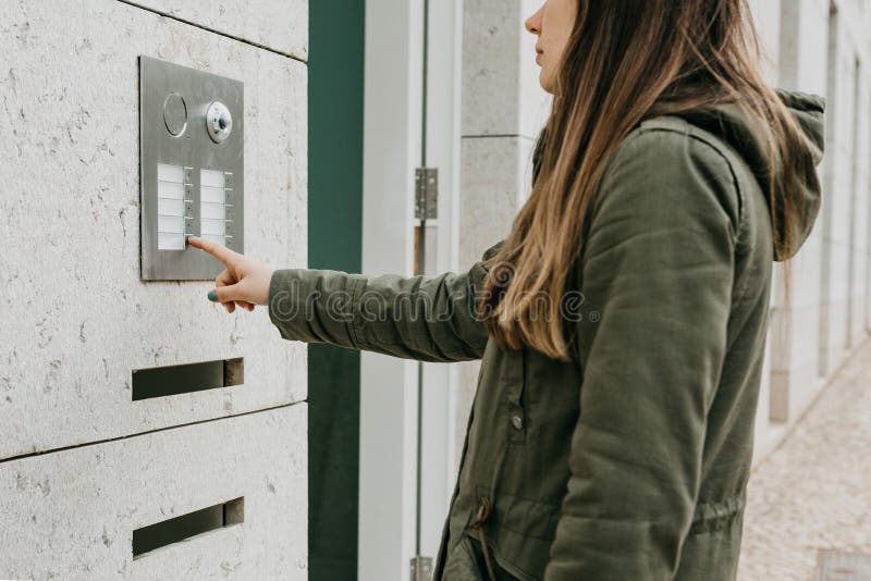 Το κορίτσι ωθεί το κουμπί doorphone ή καλεί την ενδοσυνεννόηση στοκ φωτογραφία με δικαίωμα ελεύθερης χρήσης Το κορίτσι ωθεί το κουμπί doorphone ή καλεί την ενδοσυνεννόηση στοκ φωτογραφία με δικαίωμα ελεύθερης χρήσης