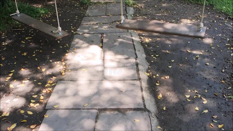 Το μήκος σε πόδηα της κενής ξύλινης ταλάντευσης με το σχοινί κινείται σε έναν κήπο απόθεμα βίντεο