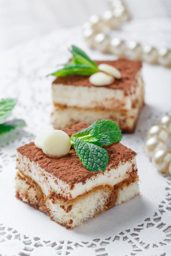 Το μίνι tiramisu κέικ με την άσπρη σοκολάτα, το κακάο και οι καραμέλες στο ελαφρύ υπόβαθρο κλείνουν επάνω Εύγευστος φραγμός επιδο στοκ εικόνα