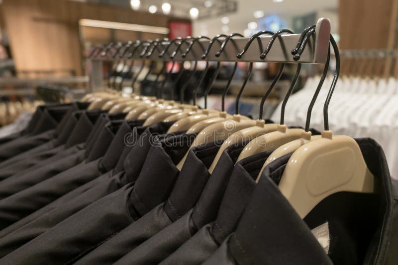 Το μαύρο και μπλε πουκάμισο κρεμά στο ράφι, πουκάμισα ατόμων ` s στις κρεμάστρες στην ντουλάπα στοκ εικόνες Το μαύρο και μπλε πουκάμισο κρεμά στο ράφι, πουκάμισα ατόμων ` s στις κρεμάστρες στην ντουλάπα στοκ εικόνες