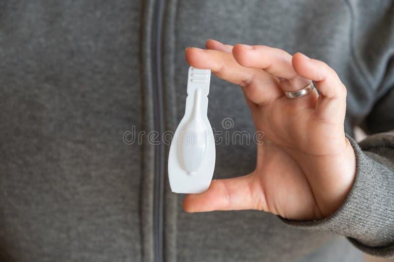 The middle section of the woman`s holding the flea tick spot-on. White sealed package with a veterinary drug for pets.  Close-up. Selective focus. The middle section of the woman`s holding the flea tick spot-on. White sealed package with a veterinary drug for pets.  Close-up. Selective focus