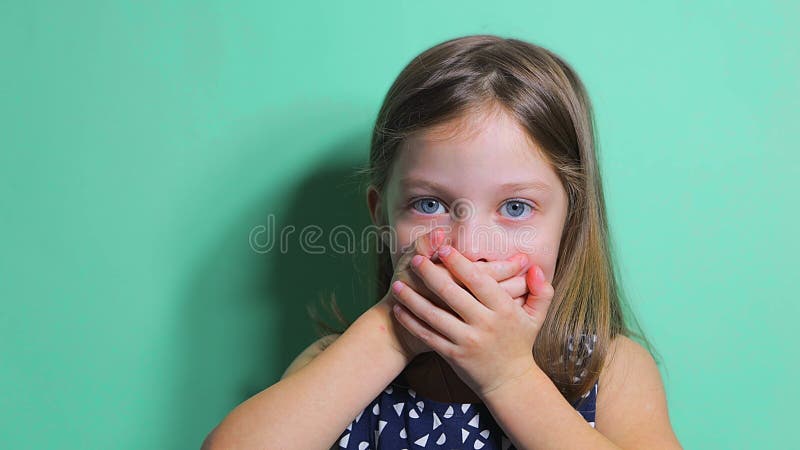 το μικρό κορίτσι κλείνει το στόμα της με φόβο και έκπληξη