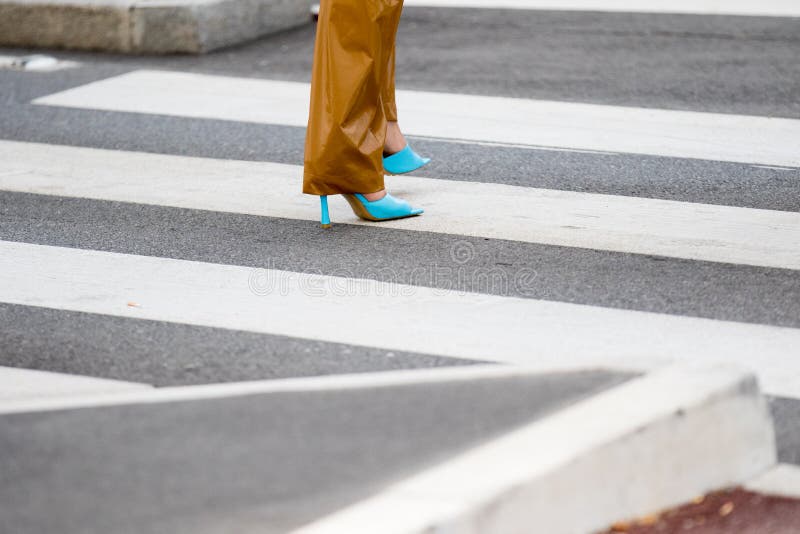 Milan, Italy - September 19, 2019: Model wears a pair of brown trousers and a pair of turquoise shoes opened with a heel and square toe during the Prada show for the spring / summer 2020 collection. Milan, Italy - September 19, 2019: Model wears a pair of brown trousers and a pair of turquoise shoes opened with a heel and square toe during the Prada show for the spring / summer 2020 collection