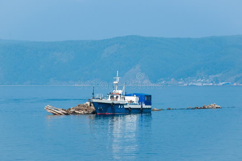 Το μπλε σκάφος έδεσε στη λίμνη Baikal στοκ φωτογραφία με δικαίωμα ελεύθερης χρήσης Το μπλε σκάφος έδεσε στη λίμνη Baikal στοκ φωτογραφία με δικαίωμα ελεύθερης χρήσης
