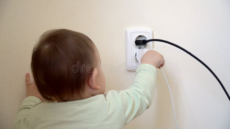 Το μωρό έφθασε στη electical υποδοχή και usb το καλώδιο από το φορτιστή, hazaard unsefety στο σπίτι με τα μικρά παιδιά στοκ φωτογραφία με δικαίωμα ελεύθερης χρήσης Το μωρό έφθασε στη electical υποδοχή και usb το καλώδιο από το φορτιστή, hazaard unsefety στο σπίτι με τα μικρά παιδιά στοκ φωτογραφία με δικαίωμα ελεύθερης χρήσης