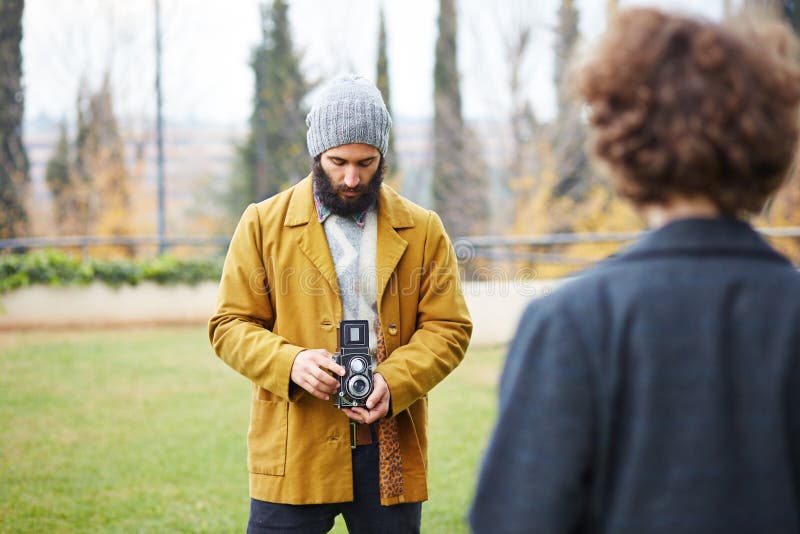 Το νέο γενειοφόρο hipster που παίρνει τη φωτογραφία στο redhead κορίτσι με TLR ήρθε στοκ φωτογραφία με δικαίωμα ελεύθερης χρήσης Το νέο γενειοφόρο hipster που παίρνει τη φωτογραφία στο redhead κορίτσι με TLR ήρθε στοκ φωτογραφία με δικαίωμα ελεύθερης χρήσης
