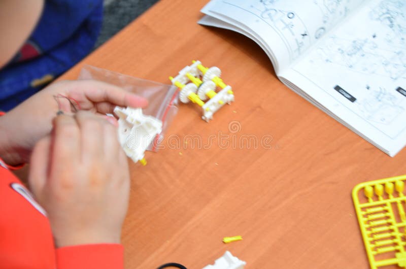 το παιδί δουλεύει σε μια κατασκευή ρομπότ στο δωμάτιό του. έξυπνος νεαρός μαθητής μαθητής που σπουδάζει ηλεκτρονικά παρηγοριά στοκ φωτογραφία