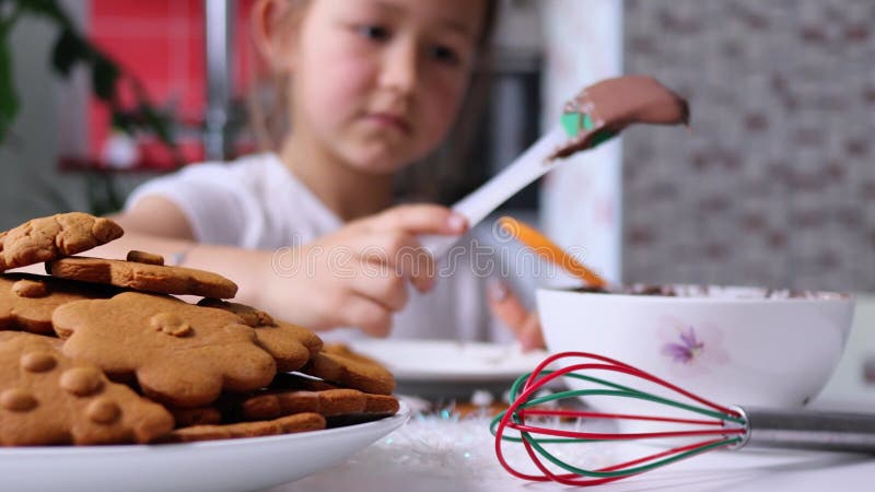 το πιάτο με τα χριστουγεννιάτικα κουλουράκια με το κοριτσάκι το διακοσμεί στο φόντο