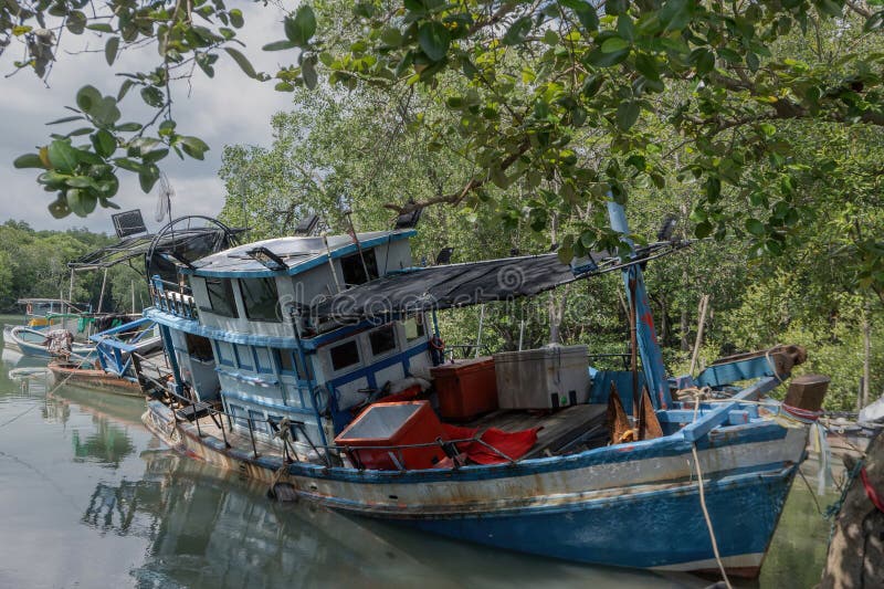 το πολύχρωμο παραδοσιακό ξύλινο αλιευτικό σκάφος προσάραξε στα ρηχά νερά του καναλιού δάσους mangrove στοκ φωτογραφία με δικαίωμα ελεύθερης χρήσης