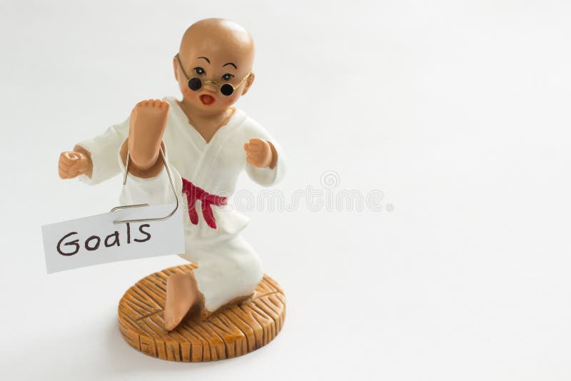 The sign with the word Goals hanging on the foot karateka. White background. The sign with the word Goals hanging on the foot karateka. White background