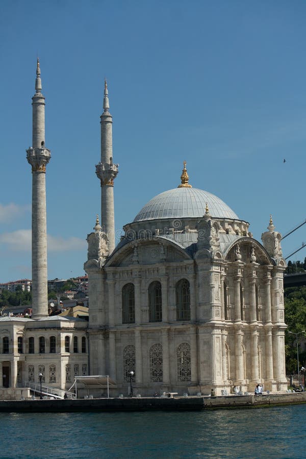 Το τζαμί Ortakoy στέκεται με μεγάλη πλειοψηφία δίπλα στο Βόσπορο στην Κωνσταντινούπολη με καθαρό μπλε ουρανό πάνω στοκ εικόνα