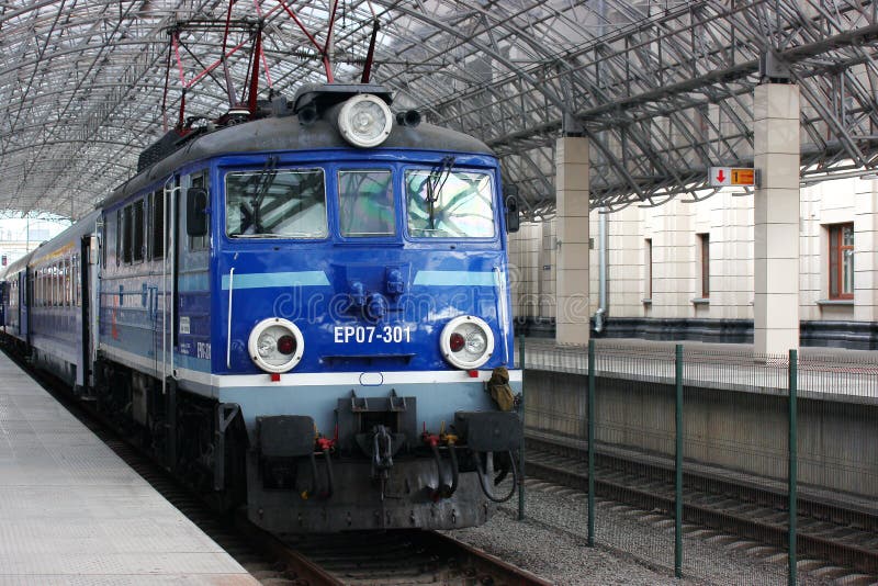 Το τραίνο είναι στην πλατφόρμα περιμένοντας τους επιβάτες αναχώρηση στο πρόγραμμα το παλαιό πρότυπο της μπλε μηχανής επιβάτης στοκ φωτογραφία με δικαίωμα ελεύθερης χρήσης Το τραίνο είναι στην πλατφόρμα περιμένοντας τους επιβάτες αναχώρηση στο πρόγραμμα το παλαιό πρότυπο της μπλε μηχανής επιβάτης στοκ φωτογραφία με δικαίωμα ελεύθερης χρήσης