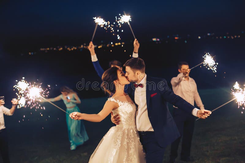 Το φιλί newlyweds και κρατά το sparkler στοκ εικόνες με δικαίωμα ελεύθερης χρήσης