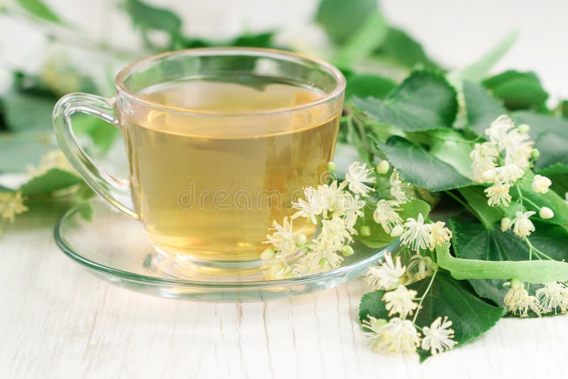 Cup of tea and linden flowers on wooden background. Cup of tea and linden flowers on wooden background