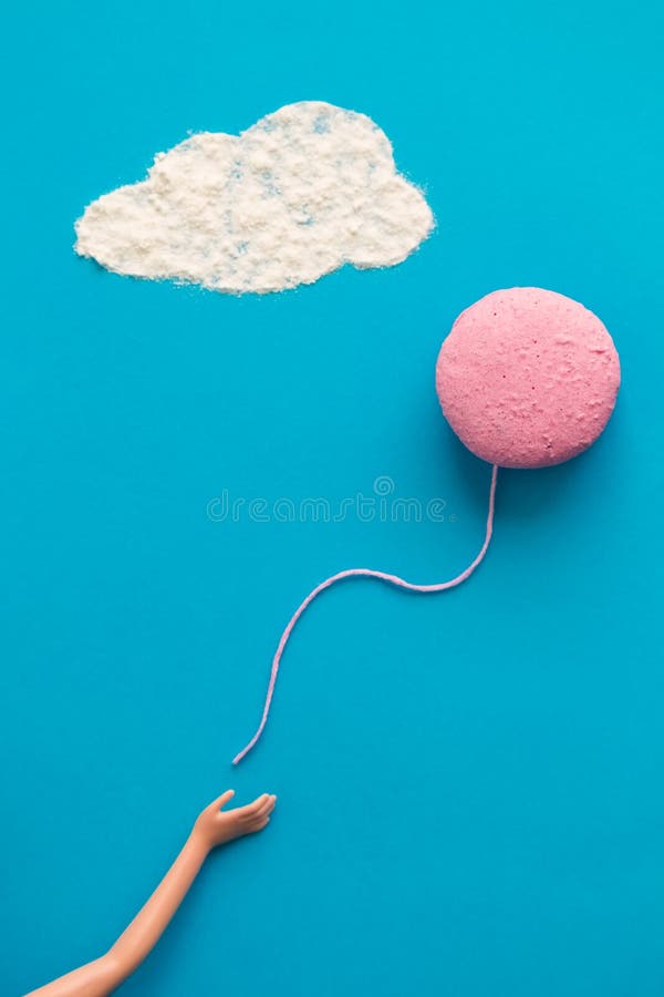 Το χέρι κουκλών απελευθερώνει macaron την αφηρημένη έννοια μπαλονιών στοκ φωτογραφία