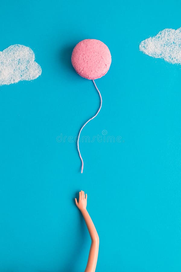 Το χέρι κουκλών απελευθερώνει macaron την αφηρημένη έννοια μπαλονιών στοκ εικόνες με δικαίωμα ελεύθερης χρήσης
