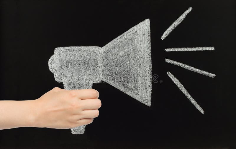 Το χέρι κρατά megaphone κιμωλίας επισυμένο την προσοχή στον πίνακα στοκ εικόνα