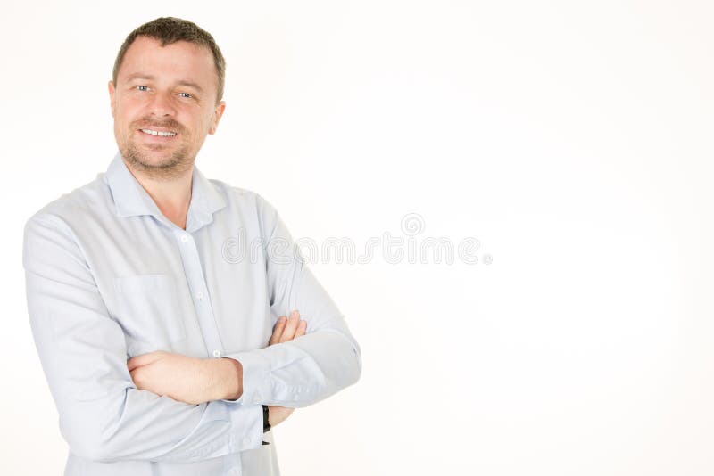 το όμορφο άτομο στο πουκάμισο οπλίζει διασχισμένος και χαμογελώντας στεμένος στο άσπρο κλίμα στοκ φωτογραφία με δικαίωμα ελεύθερης χρήσης το όμορφο άτομο στο πουκάμισο οπλίζει διασχισμένος και χαμογελώντας στεμένος στο άσπρο κλίμα στοκ φωτογραφία με δικαίωμα ελεύθερης χρήσης