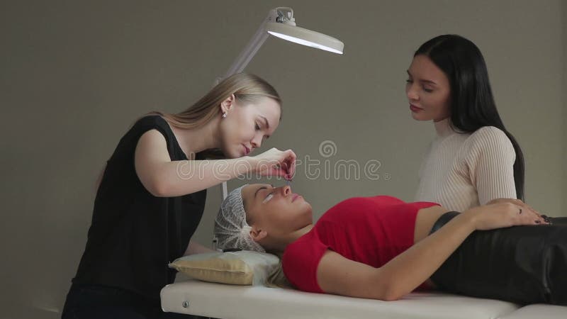 Το όμορφο νέο κορίτσι θαυμάζει eyelashes, το οποίο η συγκέντρωσή της σε ένα σαλόνι ομορφιάς απόθεμα βίντεο Το όμορφο νέο κορίτσι θαυμάζει eyelashes, το οποίο η συγκέντρωσή της σε ένα σαλόνι ομορφιάς απόθεμα βίντεο