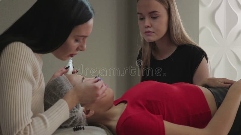 Το όμορφο νέο κορίτσι θαυμάζει eyelashes, το οποίο η συγκέντρωσή της σε ένα σαλόνι ομορφιάς απόθεμα βίντεο Το όμορφο νέο κορίτσι θαυμάζει eyelashes, το οποίο η συγκέντρωσή της σε ένα σαλόνι ομορφιάς απόθεμα βίντεο