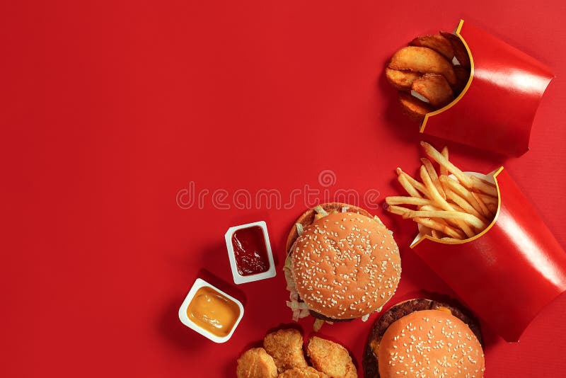 Τοπ άποψη πιάτων γρήγορου φαγητού Burger κρέατος, τσιπ πατατών και ψήγματα στο κόκκινο υπόβαθρο Take-$l*away σύνθεση
