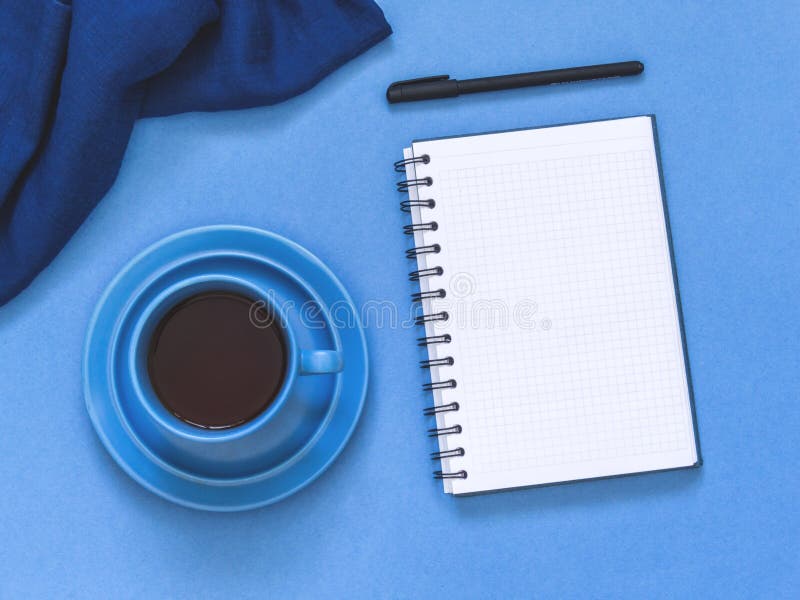 Top view goals list with notebook, cup of coffee on blue background. Flat lay, copy space. Top view goals list with notebook, cup of coffee on blue background. Flat lay, copy space