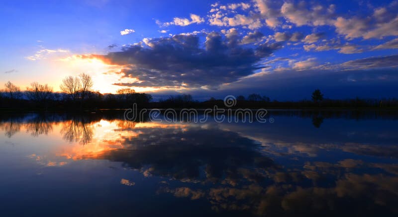 Lake landscape with cloud reflections . Lake landscape with cloud reflections .