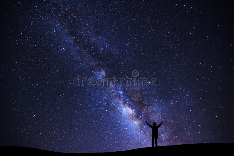 Landscape with milky way galaxy, Starry night sky with stars and silhouette of a standing sporty man with raised up arms on high mountain. Landscape with milky way galaxy, Starry night sky with stars and silhouette of a standing sporty man with raised up arms on high mountain.