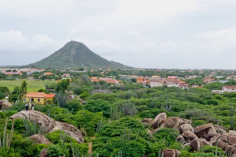 Scenic landscape of Aruba island with houses surrounded by jungle, mountain in background, Lesser Antilles. Scenic landscape of Aruba island with houses surrounded by jungle, mountain in background, Lesser Antilles.