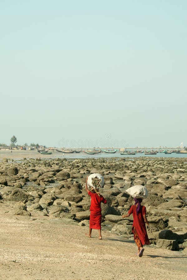 Two girls carrying bags on the beach on St. Martins Island, Bangladesh. Two girls carrying bags on the beach on St. Martins Island, Bangladesh