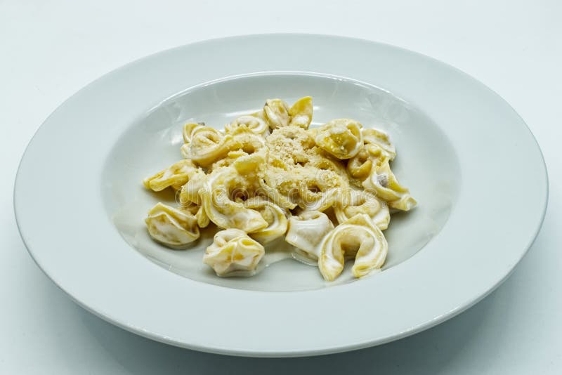 τορτελλίνι αλά πάννα με τυρί parmigiano reggiano σε λευκό πιάτο. παραδοσιακά ιταλικά ζυμαρικά. στοκ εικόνες