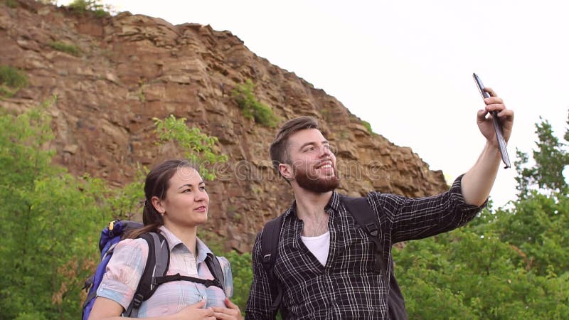 Τουρίστες που παίρνουν selfie στο υπόβαθρο των βουνών