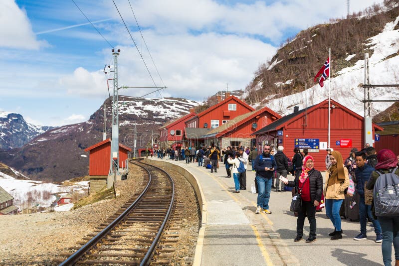 MYRDAL, NORWAY - MAY 17, 2016: Tourists wait at the Myrdal station for the train that will bring them to Flam, a village along the fjord in Norway. MYRDAL, NORWAY - MAY 17, 2016: Tourists wait at the Myrdal station for the train that will bring them to Flam, a village along the fjord in Norway.