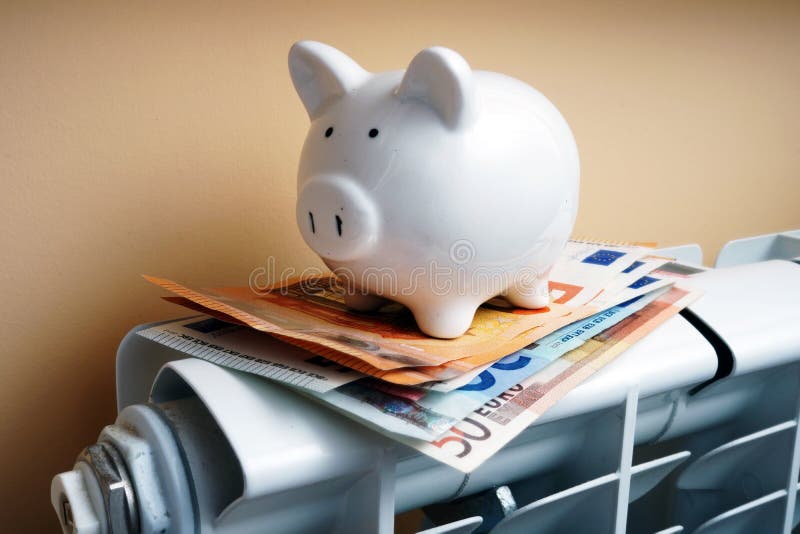 Τράπεζα Piggy και ευρο- τραπεζογραμμάτια στο θερμαντικό σώμα θέρμανσης στοκ εικόνα με δικαίωμα ελεύθερης χρήσης