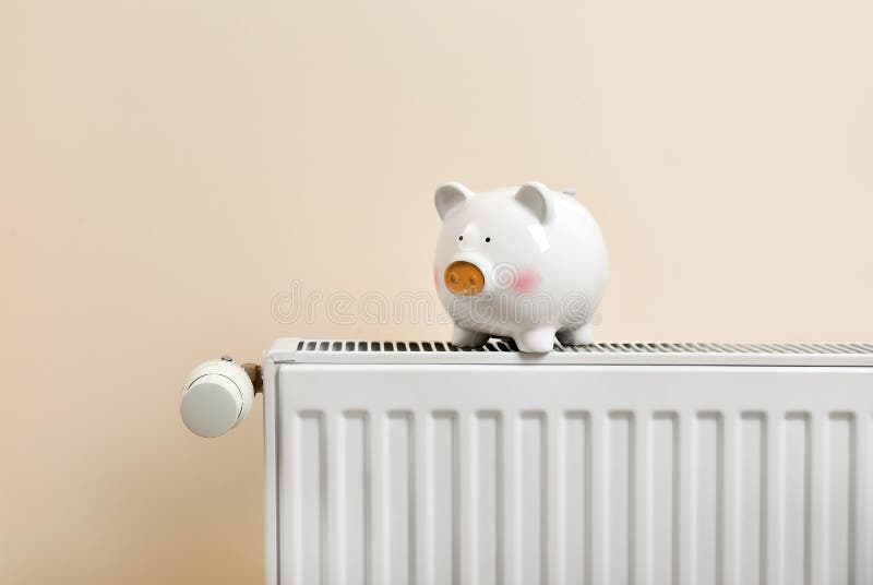 Τράπεζα Piggy στη θέρμανση του θερμαντικού σώματος στοκ εικόνες με δικαίωμα ελεύθερης χρήσης