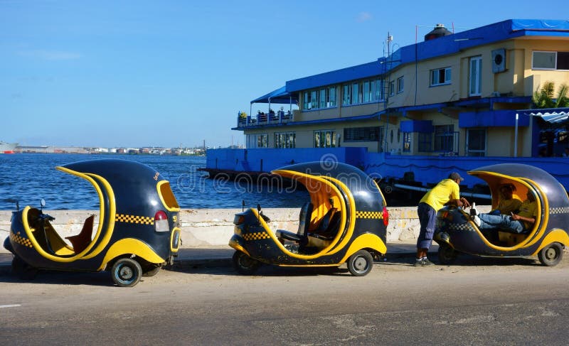 Τρία Cocotaxis και οι οδηγοί τους στο λιμάνι της Αβάνας στοκ φωτογραφία Τρία Cocotaxis και οι οδηγοί τους στο λιμάνι της Αβάνας στοκ φωτογραφία