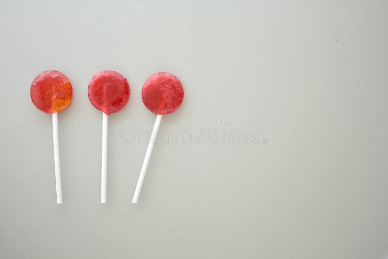Τρία lollipops που απομονώνονται σε γκρίζο χαρτί στοκ φωτογραφίες Τρία lollipops που απομονώνονται σε γκρίζο χαρτί στοκ φωτογραφίες