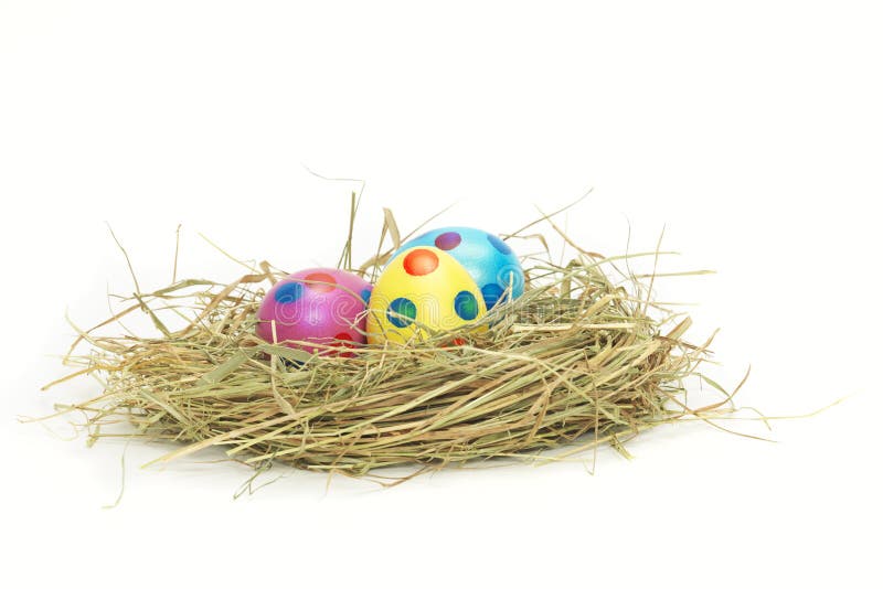 Τρία ζωηρόχρωμα αυγά Πάσχας σε μια φωλιά