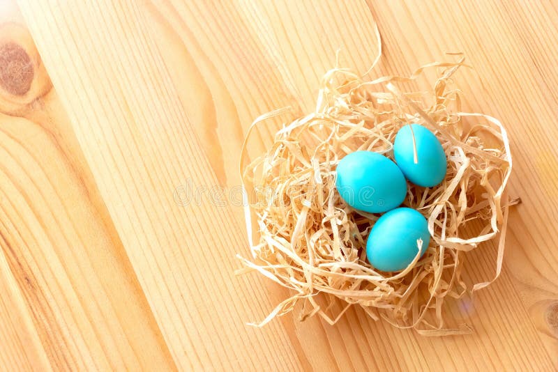 Τρία μπλε αυγά σε μια φωλιά σε ένα ελαφρύ ξύλινο υπόβαθρο Πάσχα γιορτάζει την έννοια στοκ εικόνες με δικαίωμα ελεύθερης χρήσης Τρία μπλε αυγά σε μια φωλιά σε ένα ελαφρύ ξύλινο υπόβαθρο Πάσχα γιορτάζει την έννοια στοκ εικόνες με δικαίωμα ελεύθερης χρήσης