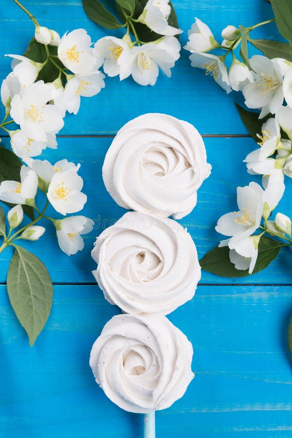 Τρία σπιτικά marshmallows μήλων που βρίσκονται σε μια σειρά στις μπλε επιτροπές, που διακοσμούνται με τα λουλούδια, μια έννοια εν στοκ φωτογραφία με δικαίωμα ελεύθερης χρήσης Τρία σπιτικά marshmallows μήλων που βρίσκονται σε μια σειρά στις μπλε επιτροπές, που διακοσμούνται με τα λουλούδια, μια έννοια εν στοκ φωτογραφία με δικαίωμα ελεύθερης χρήσης
